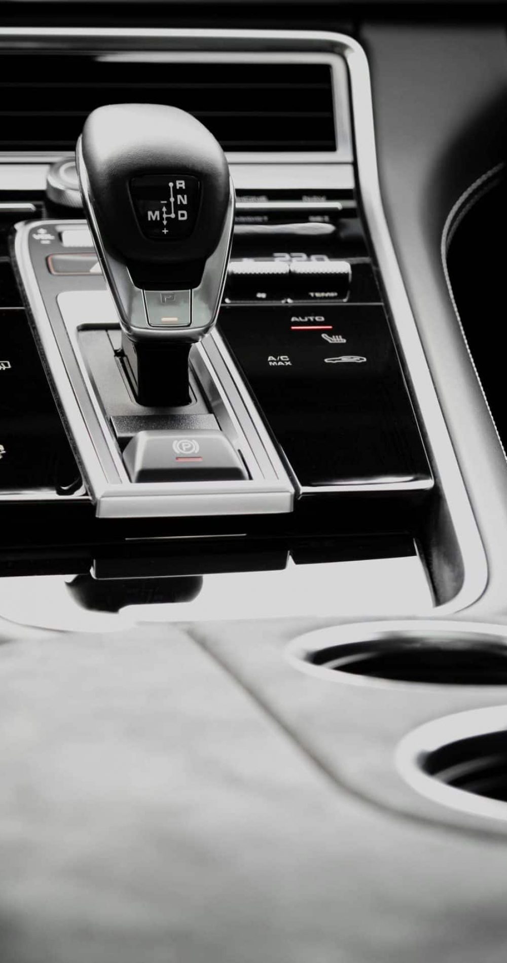 Close-up view of a modern car gearshift knob inside a monochrome vehicle interior.